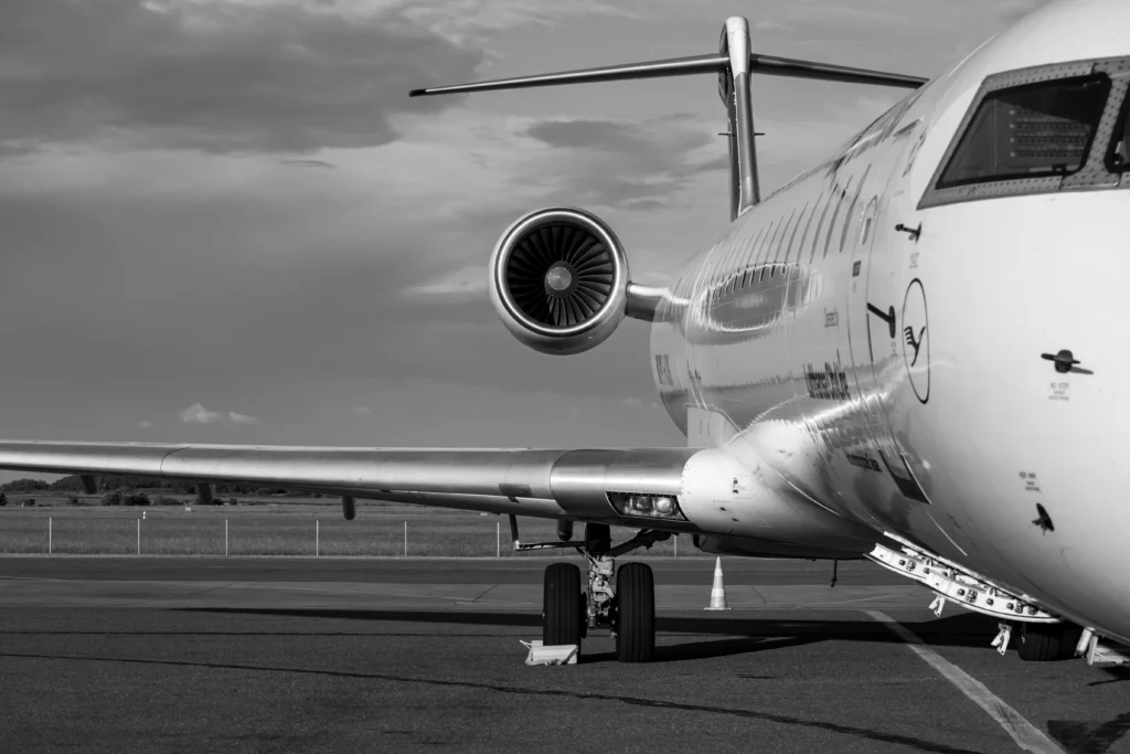Close-up of a commercial aircraft engine and rear fuselage on the tarmac with the horizontal stabilizer above.