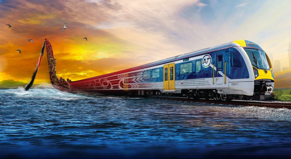 Colorful high-speed train on a coastal track at sunset, with a dragon-tail sculpture rising from the water beside it, creating a fantasy coastal scene.